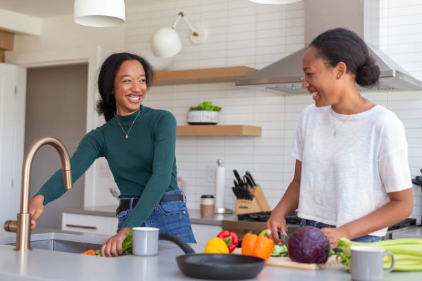 istock Sisters cooking dinner together at home 1289104375
