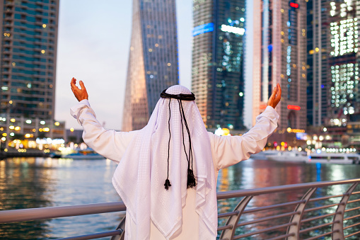 Successful Arabian Sheikh businessman against the skyscraper in Dubai Marina