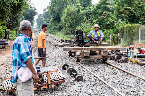 A Bamboo railroad maintenance man riding his train car to inspect the rail line. Battambang, Cambodia
