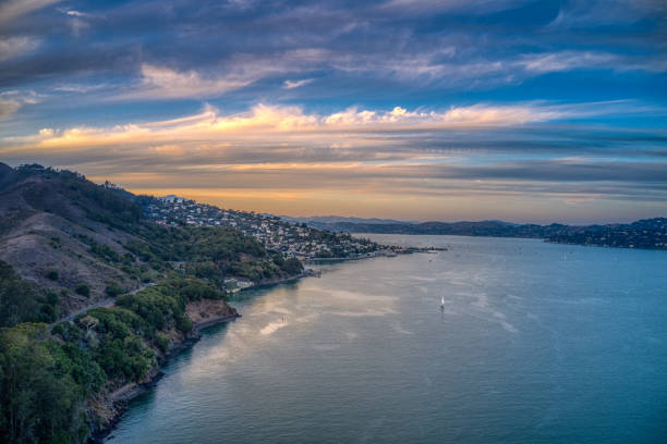 San Francisco Bay and Sausalito Aerial view looking towards Sausalito as the sun sets. A lone sailboat in the Bay. san francisco bay stock pictures, royalty-free photos & images