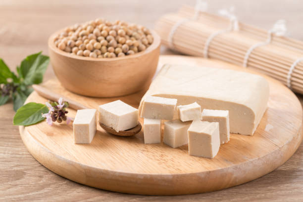 istock Cube tofu and soybean seeds on wooden cutting board 1289114845