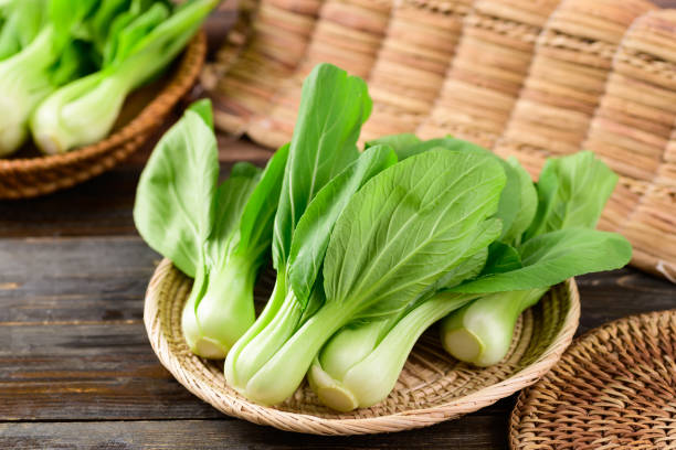 Fresh Bok Choy or Pak Choi (Chinese cabbage) Fresh Bok Choy or Pak Choi (Chinese cabbage) in bamboo basket on wooden background, Organic vegetables Bok Choy stock pictures, royalty-free photos & images