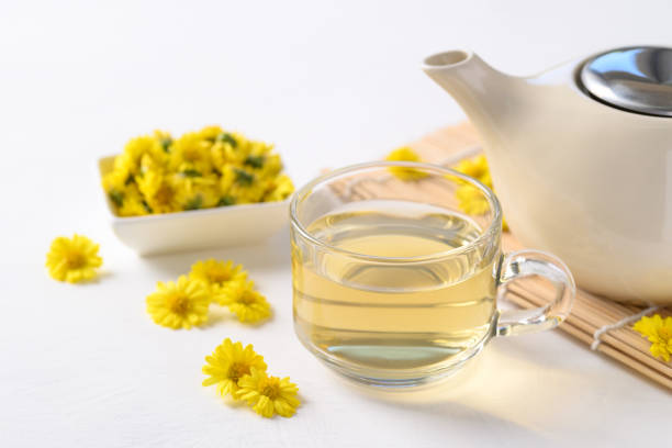 Organic Chrysanthemum flower tea in a cup and teapot on white background, Healthy Herbal drink