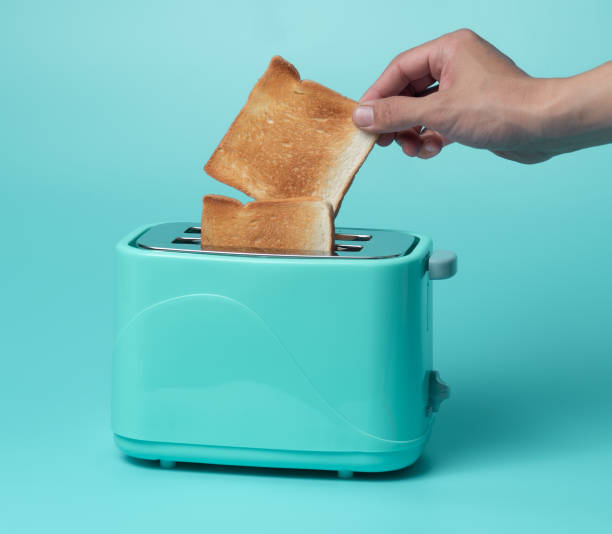 istock Toaster with bread slices on mint green background 1289121448