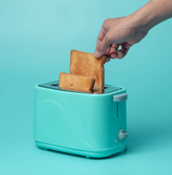 istock Toaster with bread slices on mint green background 1289121488