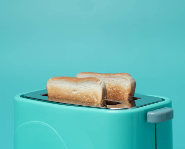 istock Toaster with bread slices on mint green background 1289121495