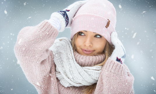 Snowy day enjoyed by a good looking female wearing woolly pink clothes and white shawl.