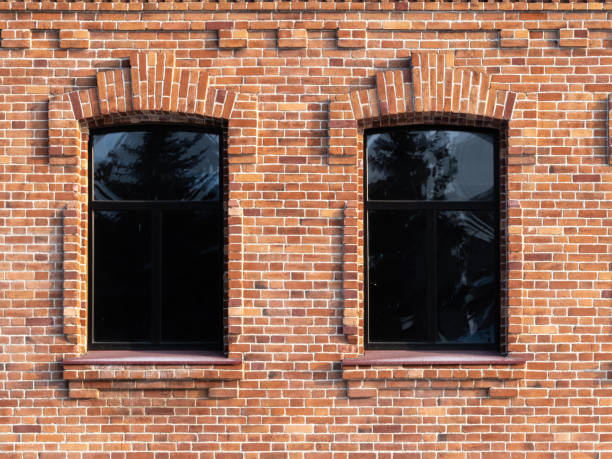 istock Two windows of the old mansion 19 century with brown bricks wall 1289133311