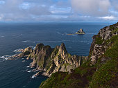 Beautiful view of the northwestern coast of Andøya island, Vesterålen, Norway with rugged mountains and cliffs as well as popular bird rock Bleiksøya in the Norwegian Sea.