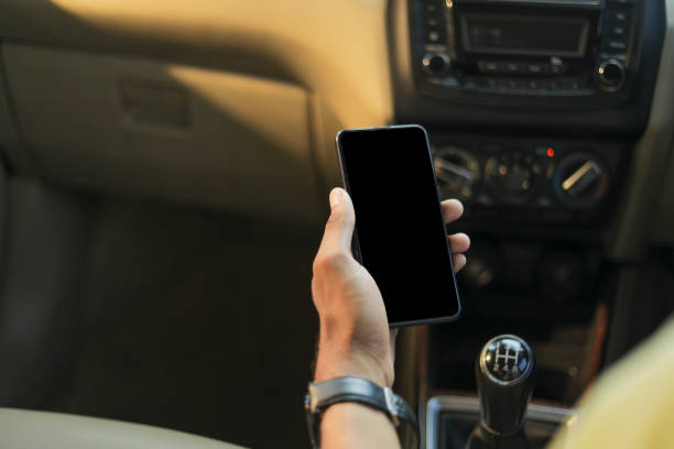 istock male hand holding mobile phone in car 1289136241