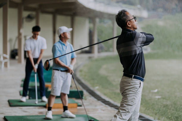 istock group of golfers playing golf at driving range 1289137194