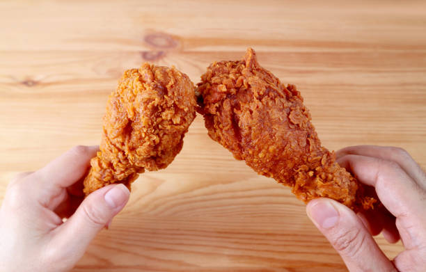 istock People's Hand Clinking Crispy Fried Chicken Drumsticks 1289137470