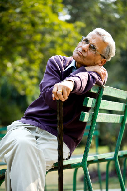 istock Thoughtful senior man sitting at park 1289138823