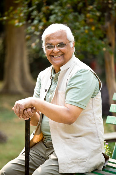 istock Happy senior man sitting at park 1289138893