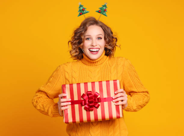 istock Glad young female with Christmas gif 1289140064