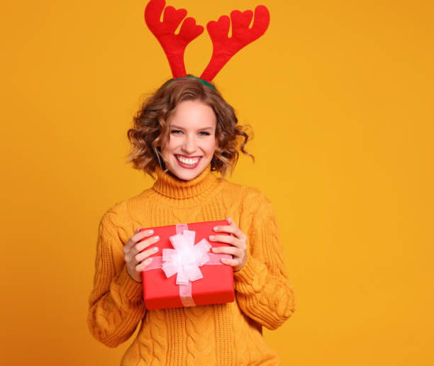 istock Glad young female with Christmas present 1289140145