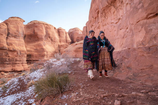 istock Cheerful Navajo sisters walking on a small path in Monument Valley - USA 1289140805