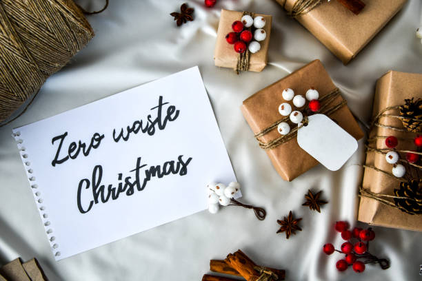 istock Zero waste Christmas text with presents with decorations on champagne colored silk background. Copy space. Eco friendly packed gift with tags from craft cardboard 1289140899