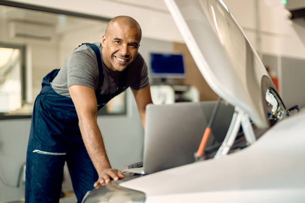 istock Happy African American mechanic using laptop while working at auto repair shop. 1289142698