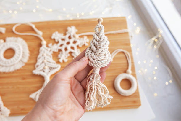 christmas macrame decor. christmas tree in the style of macramé. natural materials - cotton thread, wood beads. eco decorations, ornaments, hand made decor. winter and new year holidays - christmas tree bead humor imagens e fotografias de stock