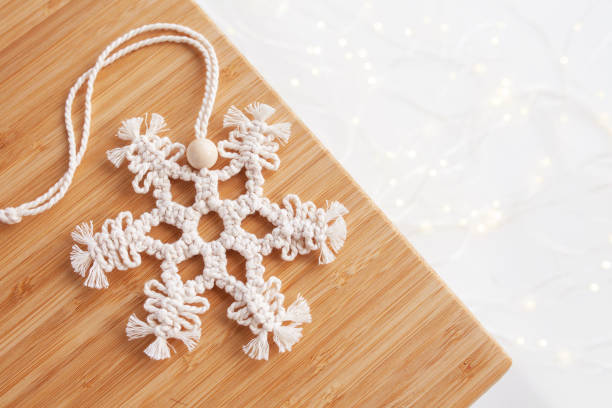 christmas macrame decor. christmas snowflake on wooden board. natural materials - cotton thread, wood beads. eco decorations, ornaments, hand made decor. winter and new year holidays. copy space - christmas tree bead humor imagens e fotografias de stock