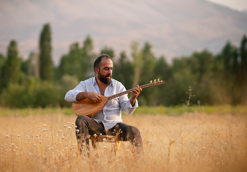 Hombre turco tocando baglama (saz) instrumento musical turco photo