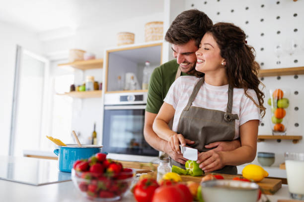 istock Happy young couple have fun in modern kitchen while preparing fresh food 1289145087