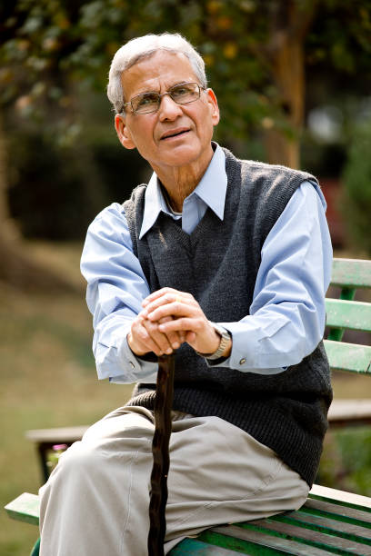 istock Senior man with walking cane at park 1289147133
