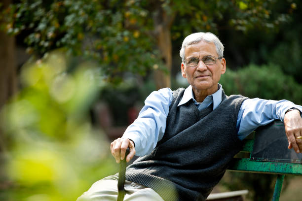 istock Happy senior man sitting at park 1289147306
