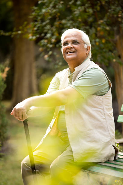 istock Happy senior man sitting at park 1289147562
