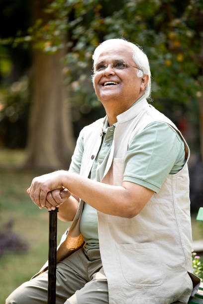 istock Happy senior man sitting at park 1289148321