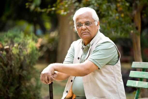 istock Senior man sitting at park 1289148378