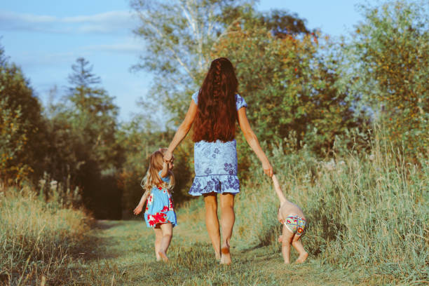 istock mother walks with children on a forest path 1289149720