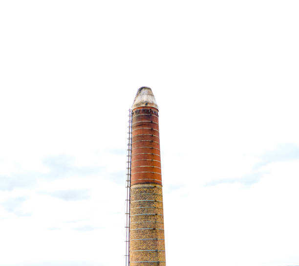istock Large industrial brick chimney with a bright white sky in the background. 1289149780