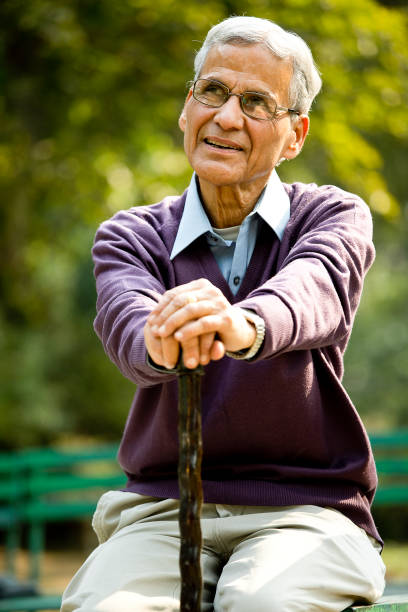 istock Happy senior man sitting at park 1289149960