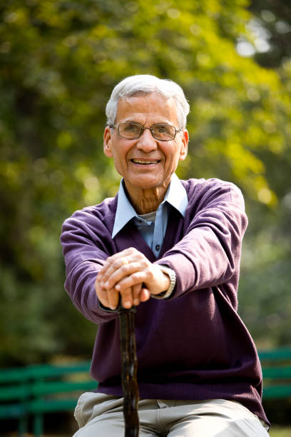istock Happy senior man sitting at park 1289150141