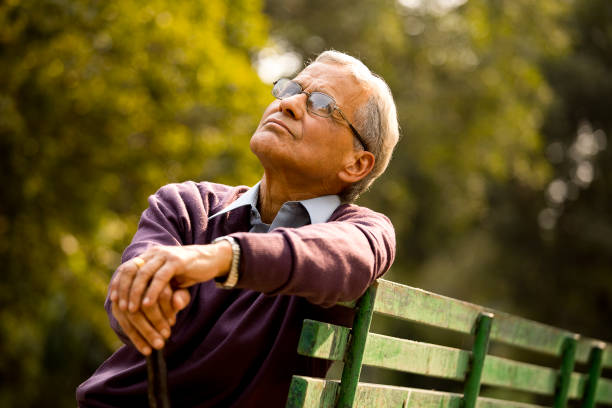 istock Thoughtful senior man sitting at park 1289150462