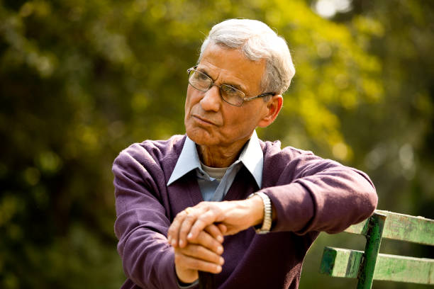 istock Thoughtful senior man sitting at park 1289150549