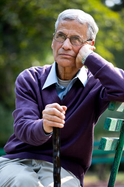 istock Thoughtful senior man sitting at park 1289150650