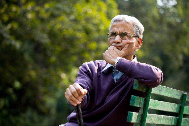 istock Thoughtful senior man sitting at park 1289150763