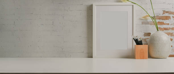 istock Worktable with mock up frame, stationery, vase and copy space in home office room 1289153069