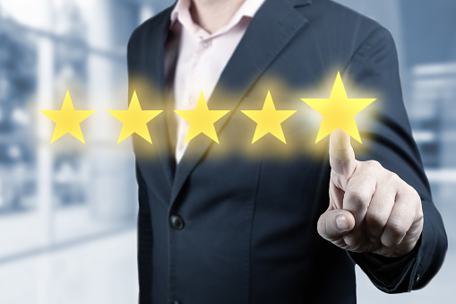 Businessman hand touching five star symbol. Man Is Pointing Five Stars - Review And Rating Concept. Person Pointing On 5 Star Review, Costumer Feedback Concept - Five Stars Rating