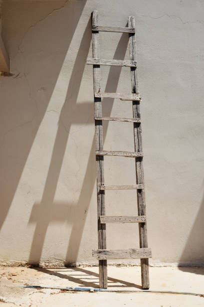 Old ladder at the empty wall of house, way to the up