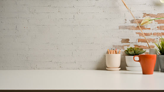 Mesa blanca con espacio de copia, lápices, taza y macetas posadas sala de oficina en casa photo