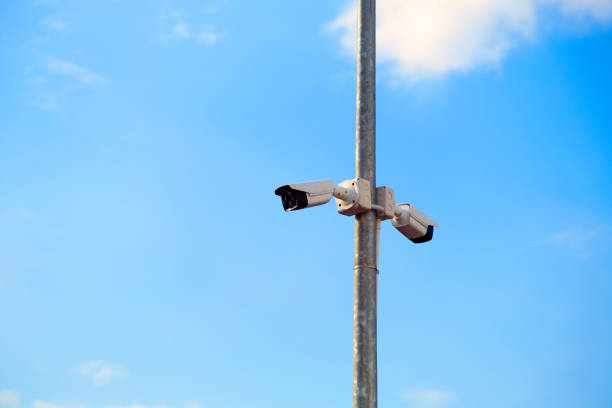 istock CCTV camera mounted on a pole in the blue sky background 1289153785
