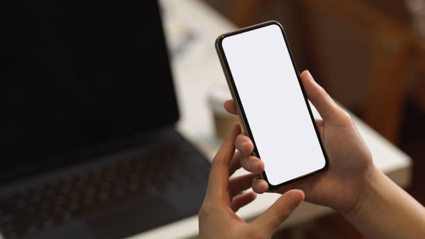 istock Female holding smartphone in blurred office room background 1289154955