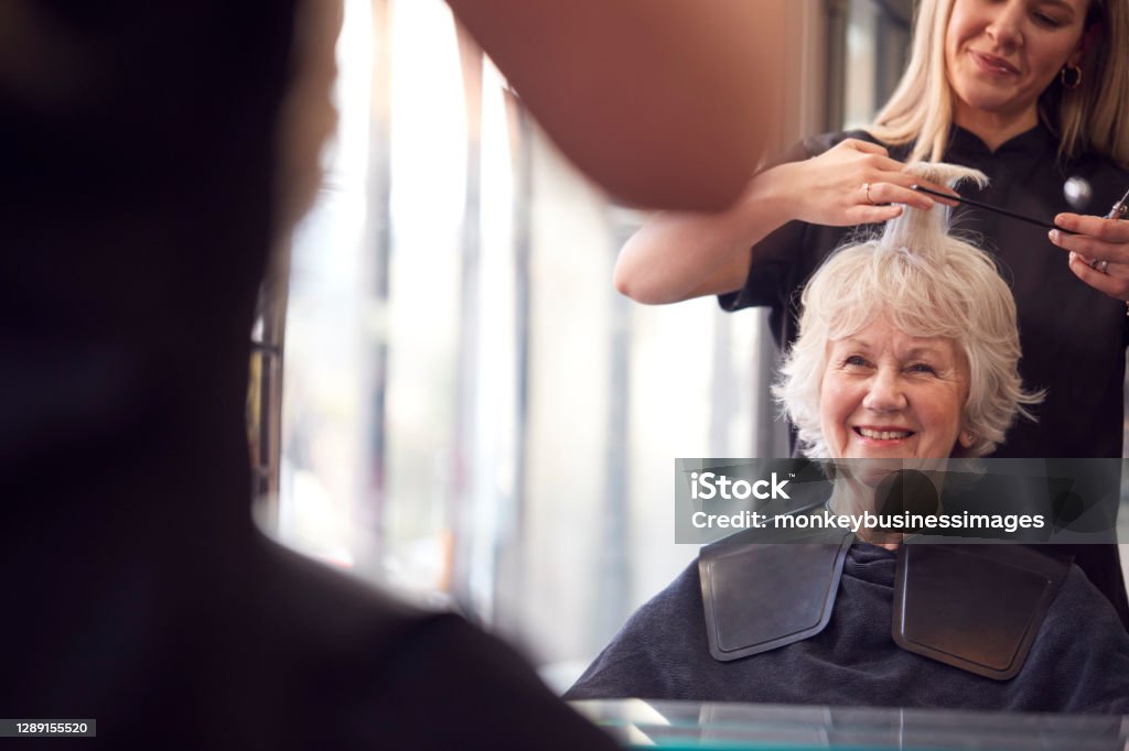 Senior Woman Having Hair Cut By Female Stylist In Hairdressing Salon Hairdresser Stock Photo