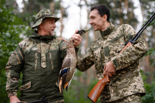 istock Excited Lucky Hunters Holding Shot Wild Duck. 1289157016