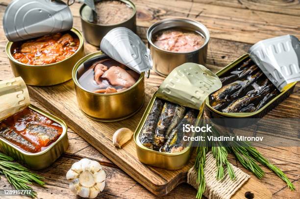 Various Canned Fish And Seafood In A Metal Cans Wooden Background Top View Stock Photo - Download Image Now