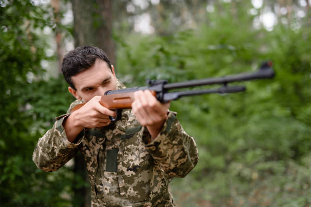 istock Shooter is Taking Aim with Rifle Hunt in Forest. 1289157896